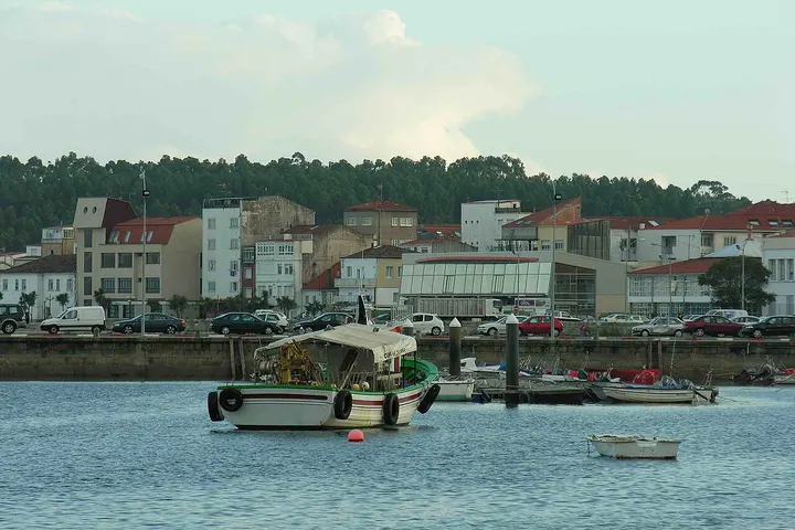 En primer plano, un barco de pesca en un puerto de mar