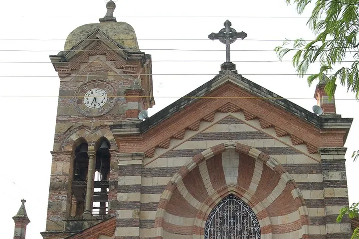 Esta es una iglesia con un reloj de torre y una cruz