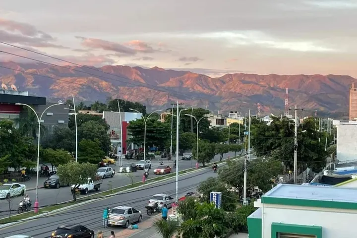 En primer plano, se ve un edificio con un techo verde y blanco