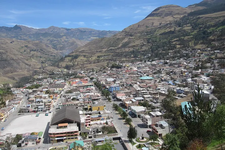 En primer plano, un estadio de fútbol se destaca en medio de un paisaje montañoso