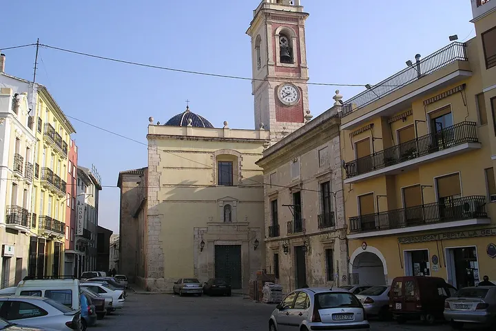 En primer plano, una iglesia con campanario y reloj