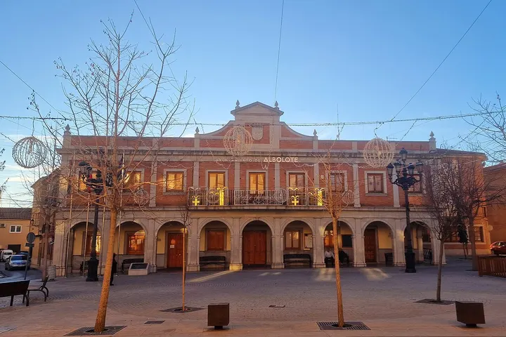 En primer plano, se ve un edificio con arcos y una palabra en la fachada