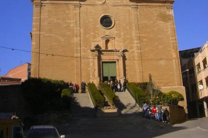 En primer plano, un edificio de ladrillo con una entrada y escaleras