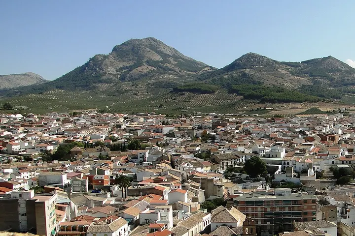 En primer plano, se ven edificios de varios pisos con tejados rojos y blancos