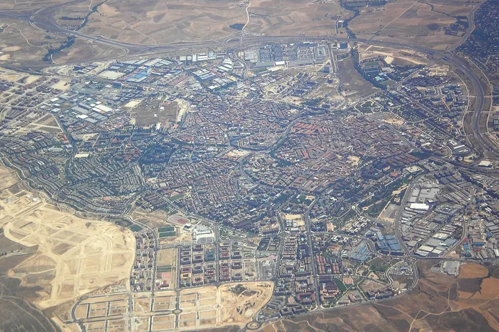 En primer plano, se aprecia un aeropuerto con pistas de aterrizaje y edificios de vuelos