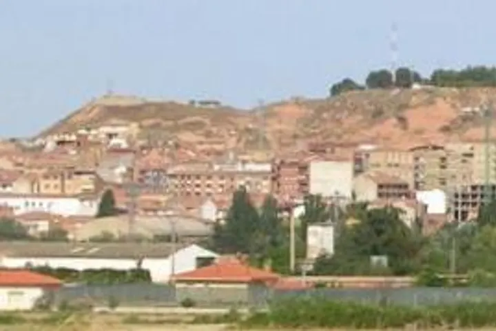 En primer plano, una granja con un techo rojo