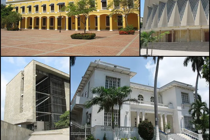 En primer plano, un edificio blanco con una entrada de dos pisos y una escalera exterior