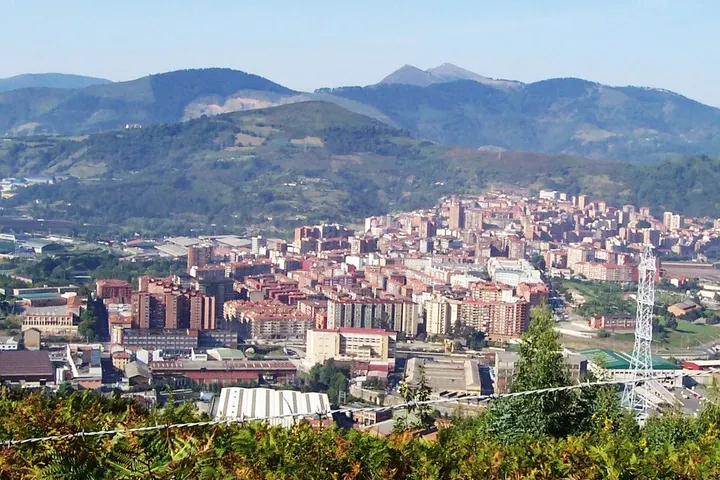 En primer plano, se ve un puente de hierro con una torre de telecomunicaciones