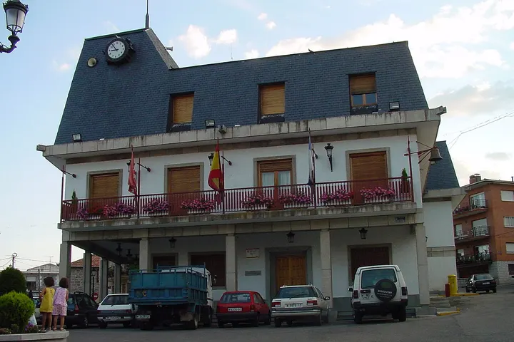 En primer plano, una gran casa blanca con un reloj en el tejado