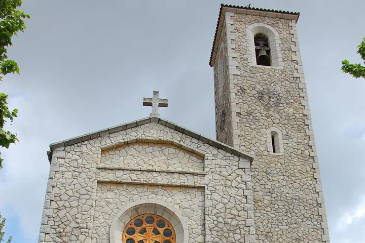 Un edificio de piedra con una cruz en la parte superior