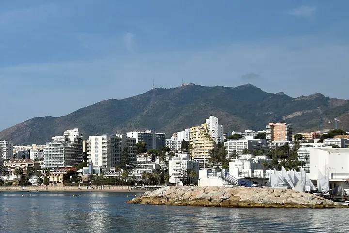 En primer plano, se ve una playa con una serie de edificios blancos