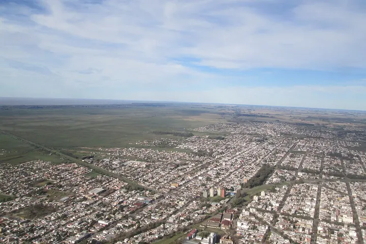 En primer plano, una gran manzana de edificios de apartamentos con un parque en el centro