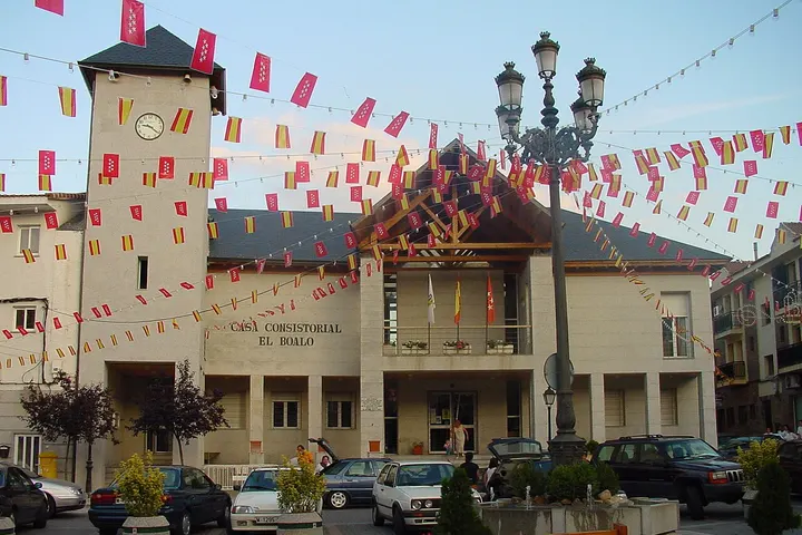 En primer plano, una torre con un reloj y una casa consistorial con el nombre de El Rincón
