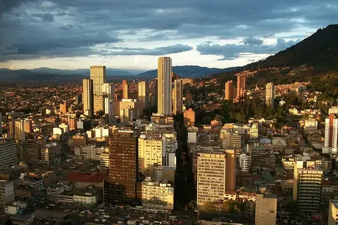 En primer plano, un edificio de oficinas de gran altura, con una torre de televisión
