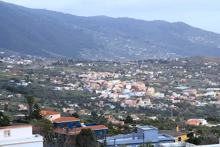 En primer plano, casas con tejados rojos y azules