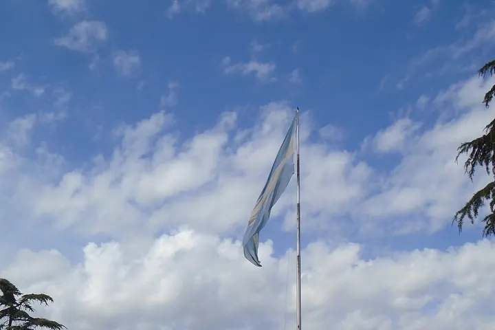 En primer plano, una bandera ondea en el viento