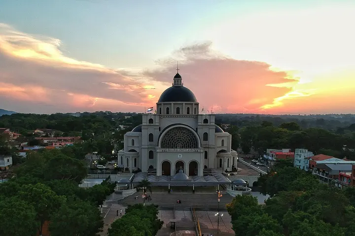 En primer plano, una iglesia blanca con una gran cúpula negra