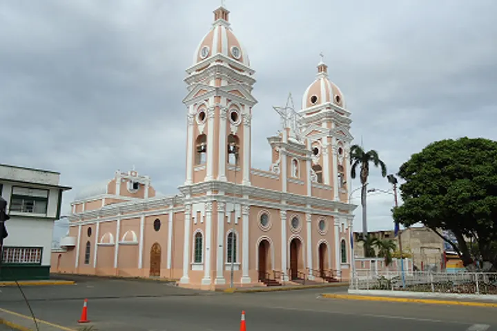 En primer plano, una iglesia con dos torres, una de ellas con una estrella