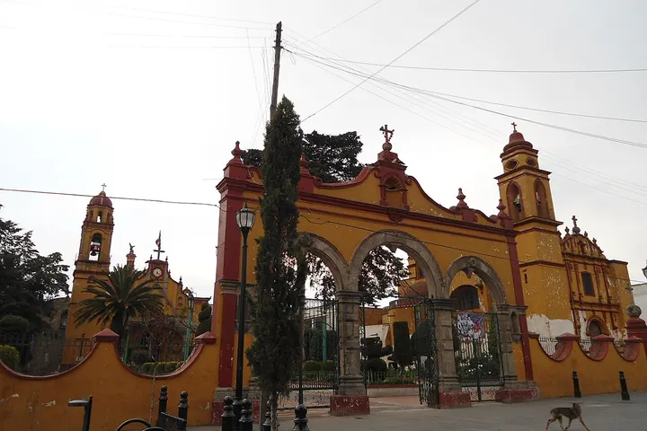 En primer plano, una iglesia con un arco de entrada y dos torres