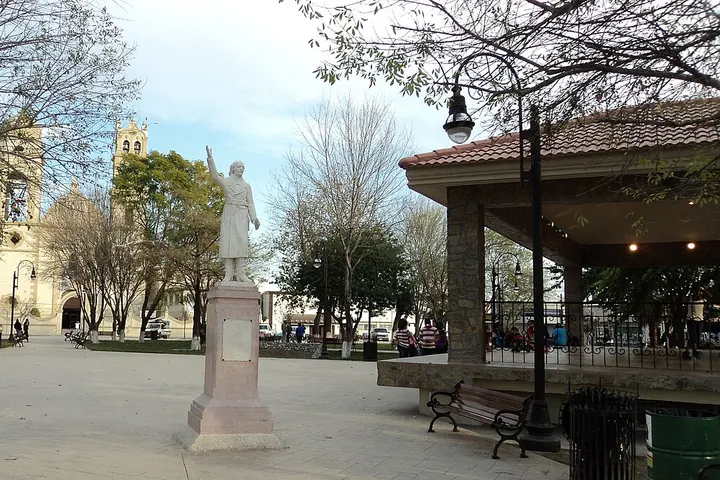 Estatua blanca sobre un pedestal en una plaza pública