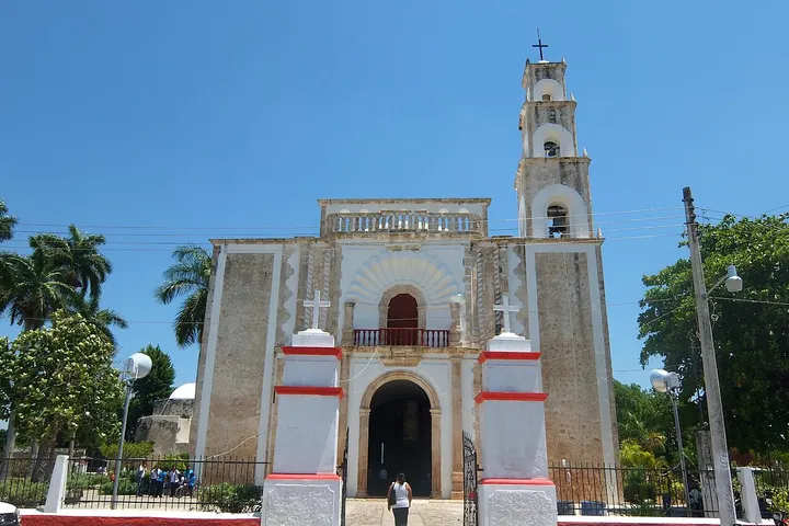 Una iglesia con un campanario y una entrada principal con dos columnas