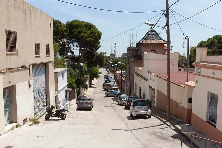 En primer plano, una mujer con un traje de vestir blanco y un scooter negro