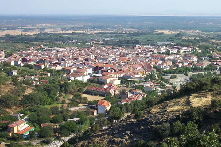 En primer plano, una iglesia con una torre y un campanario