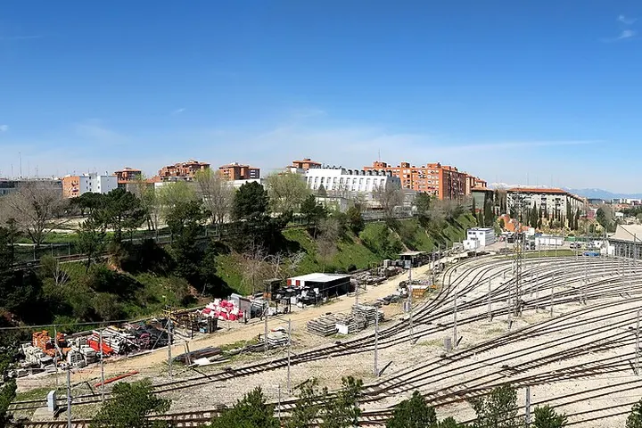 En primer plano, un gran parque de trenes de vía estrecha