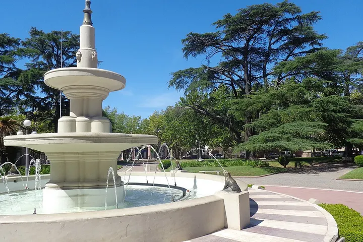 En primer plano, una fuente blanca con varios chorros de agua