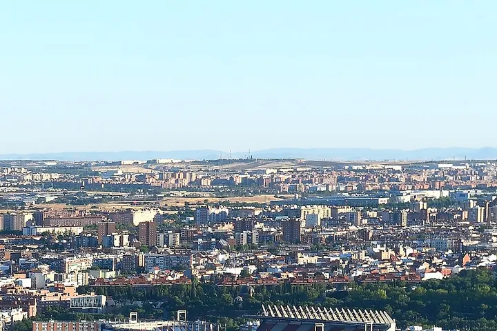 En primer plano, se aprecia un estadio de fútbol, con su característica estructura de graderías