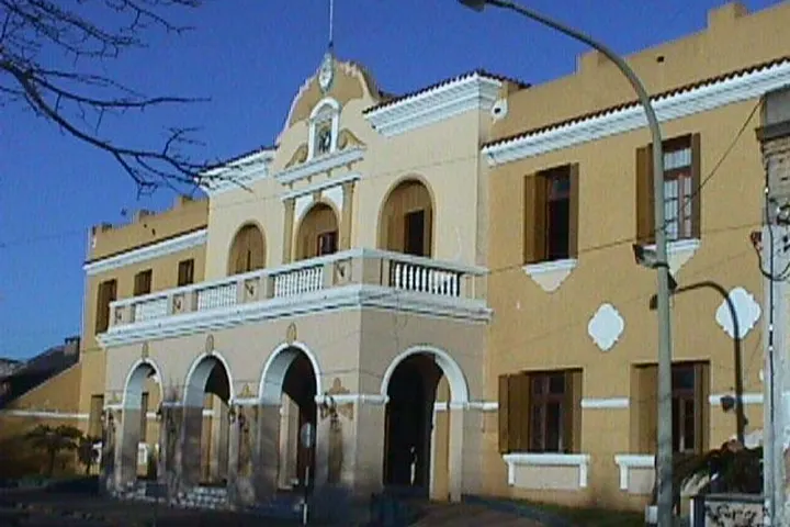 En primer plano se ve un edificio de dos pisos con arcos y balcones