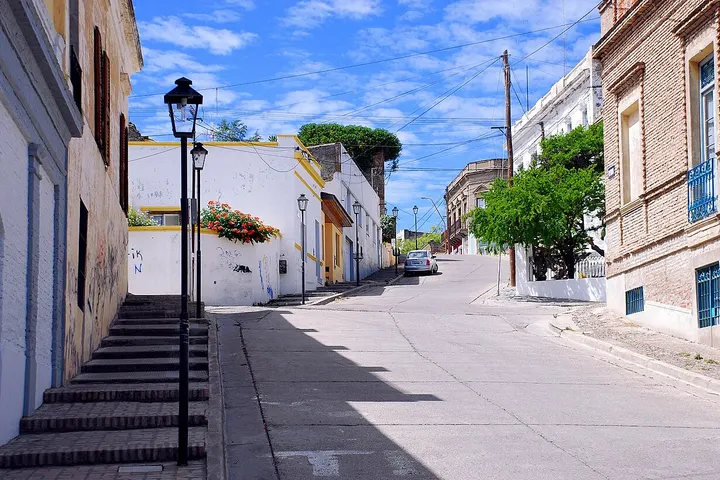 En primer plano, una escalera de piedra con una farola en el centro