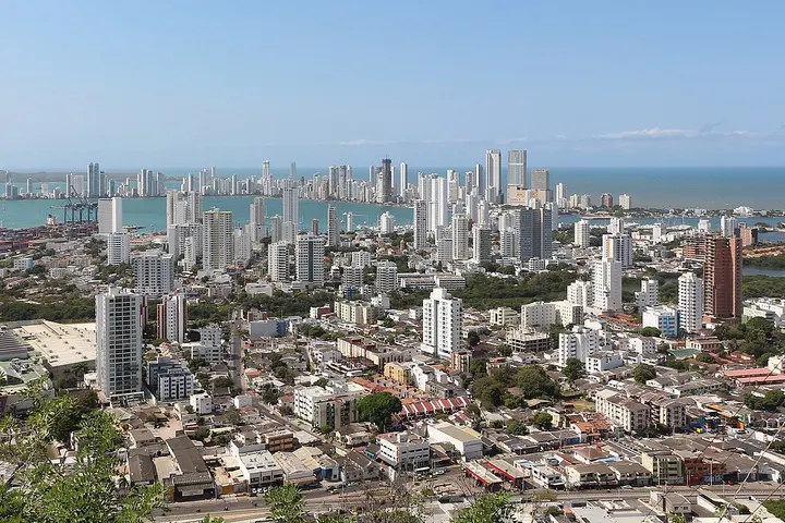 En primer plano se ve una zona residencial con edificios de varios pisos y un parque