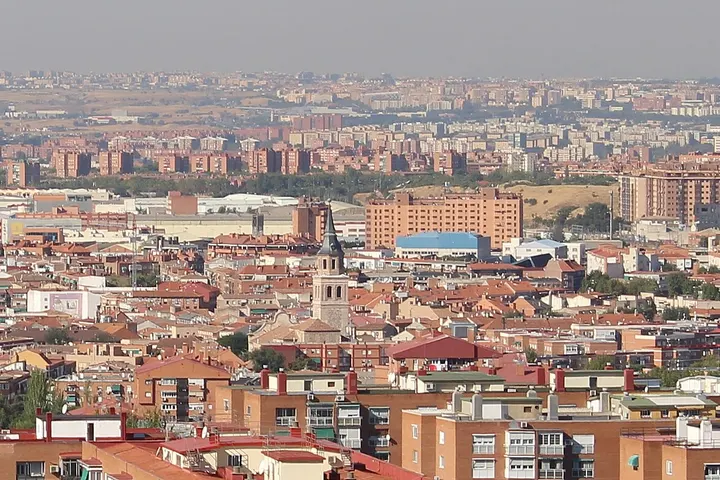 En primer plano, se ven edificios de ladrillo rojo y un campanario de una iglesia