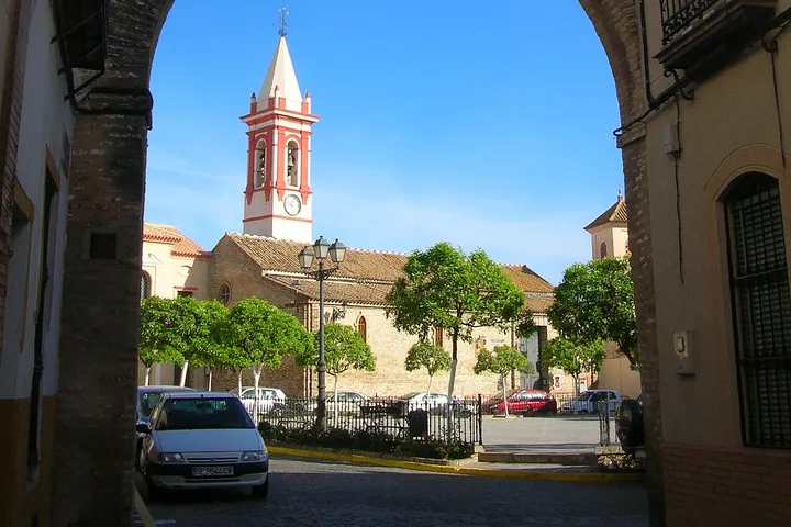 En primer plano, una iglesia con torre blanca y roja