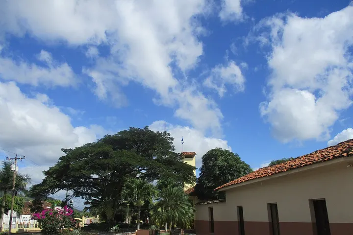 En primer plano, un edificio con una azotea de tejas rojas