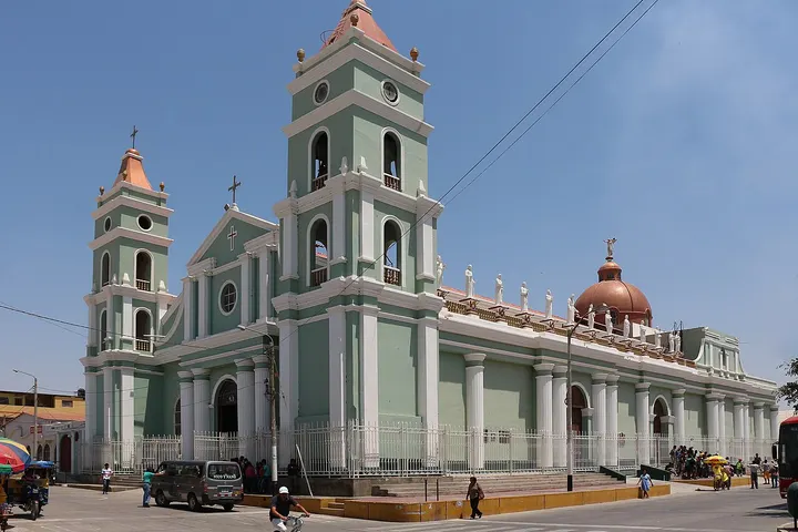 Un edificio religioso con torres y una cúpula de color rojo y verde claro