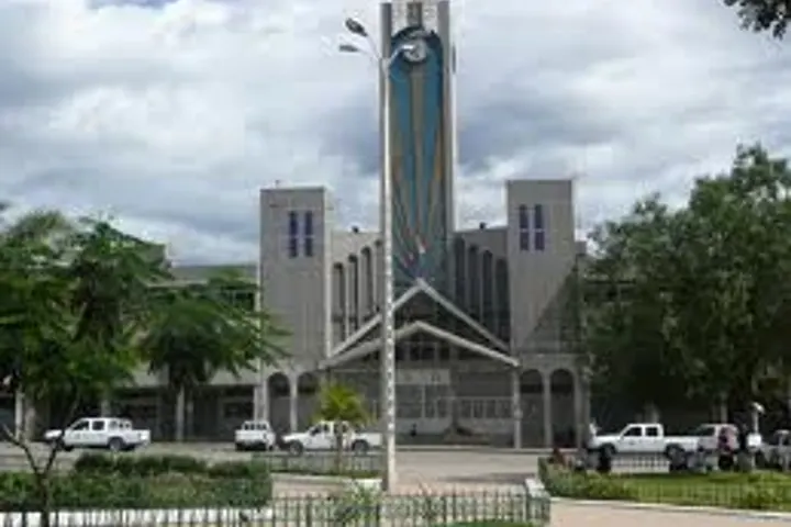 En primer plano, se ve una iglesia con un reloj en su torre