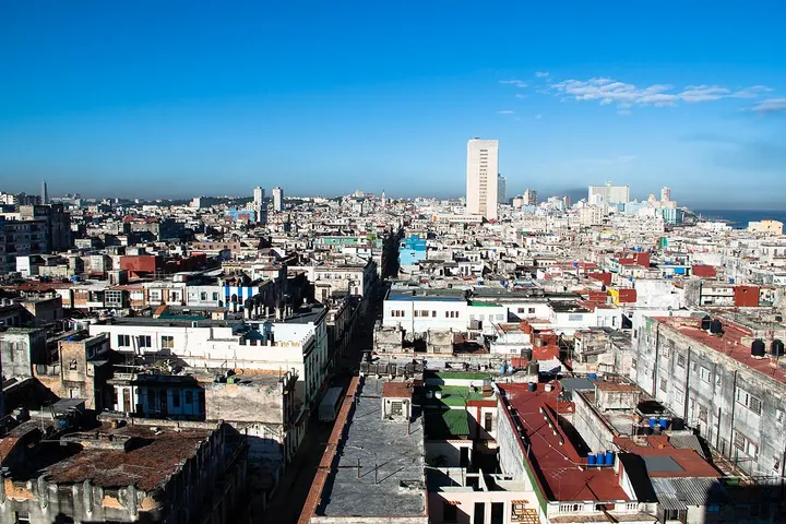 En primer plano, una calle estrecha con edificios de ladrillo y tejados rojos