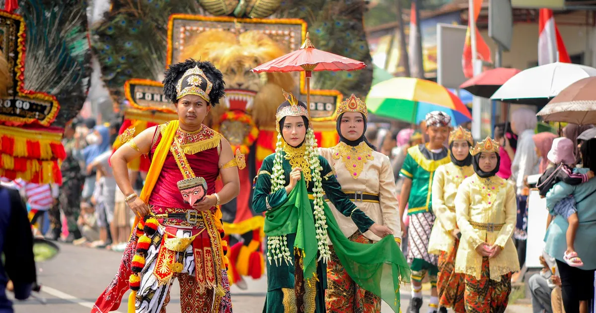Bailarines con trajes tradicionales y tocados de colores desfilan por la calle