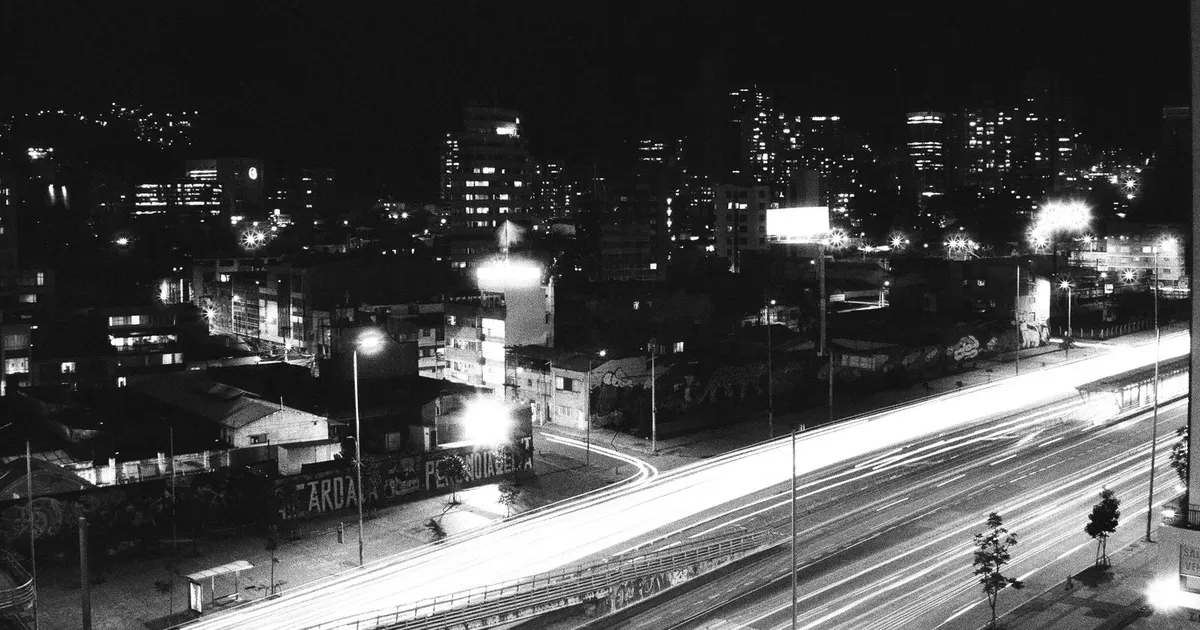 Ciudad latinoamericana iluminada al caer la noche