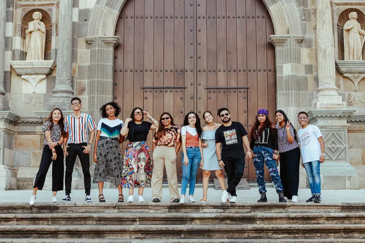 Un grupo de jóvenes, posando para una foto, en las escaleras de una iglesia