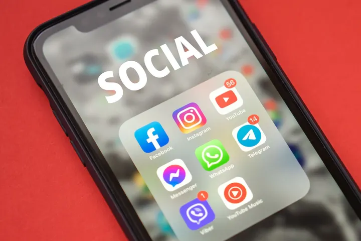 Un teléfono móvil con la aplicación de redes sociales abierta, en un fondo rojo